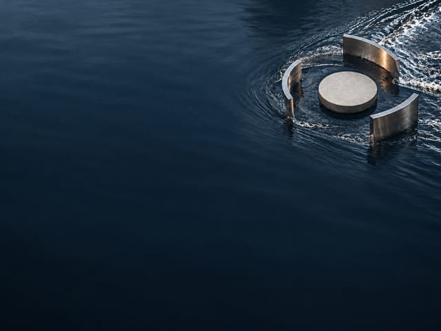 A stone disc floating on dark water, ringed by three curved steel blades breaking the current.